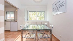 A modern kitchen with white cabinets, a dishwasher, and a large window. - Apartment in Vilamoura (Vilamoura)