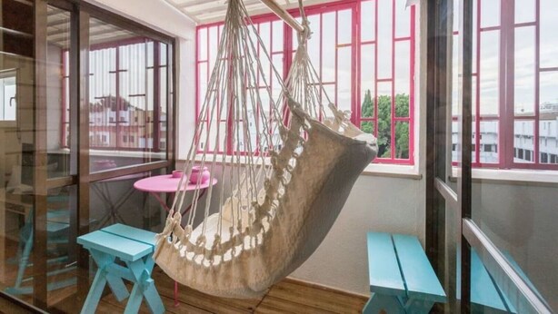 A room with a hanging hammock, a pink table, and a blue bench. - Apartment in Vilamoura (Vilamoura)