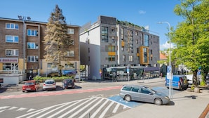 A modern urban street with multi-story buildings, a pedestrian crossing, and parked cars. - Apartamenty Sun & Snow Gdynia Centrum (Gdynia)