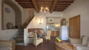 Un interno accogliente con zona pranzo, cucina e angolo salotto.