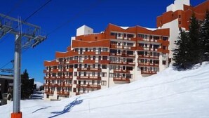 A multi-story hotel with balconies, located on a snowy slope. - 5th floor, tv, ski locker, 22m², Les Menuires (Les Menuires)