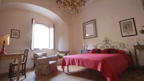 Une chambre à coucher avec un lit, une chaise, un bureau et un lustre.