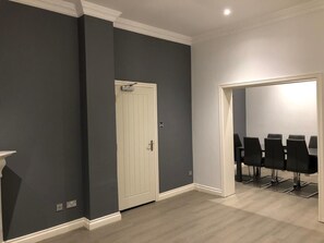 A room with dark grey walls, a white door, and a seating area with black chairs. - Catherines House (Solihull)