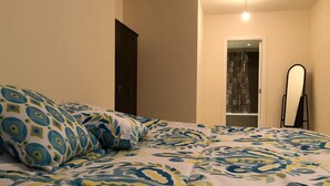 A bedroom with a bed, pillows, a wardrobe, and a mirror. - Family-Friendly Home in Greater Beirut (Baabda)