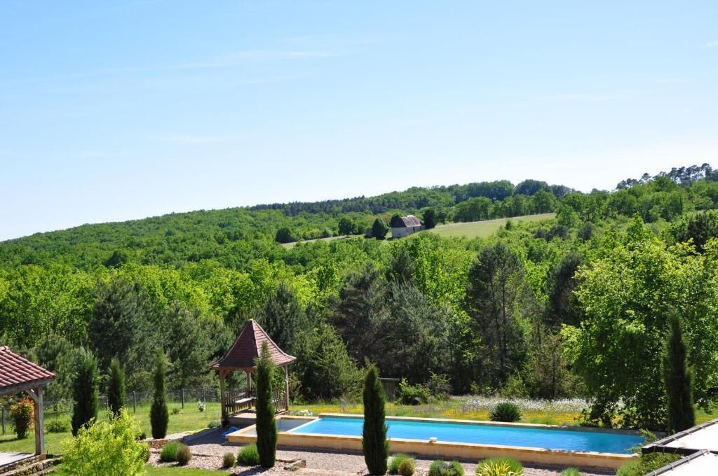 Une piscine dotée d’un belvédère et offrant une vue sur un paysage vallonné.