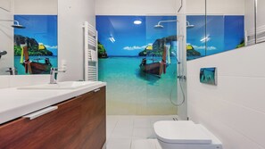 Une salle de bain avec un grand miroir, une douche, des toilettes et un lavabo.
