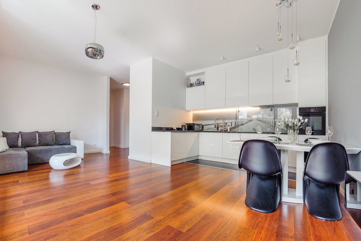 Un appartement moderne comprenant un espace de vie, une cuisine et un coin repas.