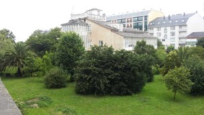 Un jardín con varios árboles y un edificio al fondo.