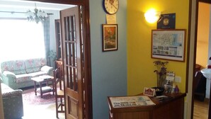 Un área de recepción con un escritorio de madera, un reloj y un mapa enmarcado en la pared.