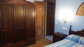 A bedroom with a bed, a nightstand, a wardrobe, and a door. - Hospedaxe Carragal (Ribadeo)