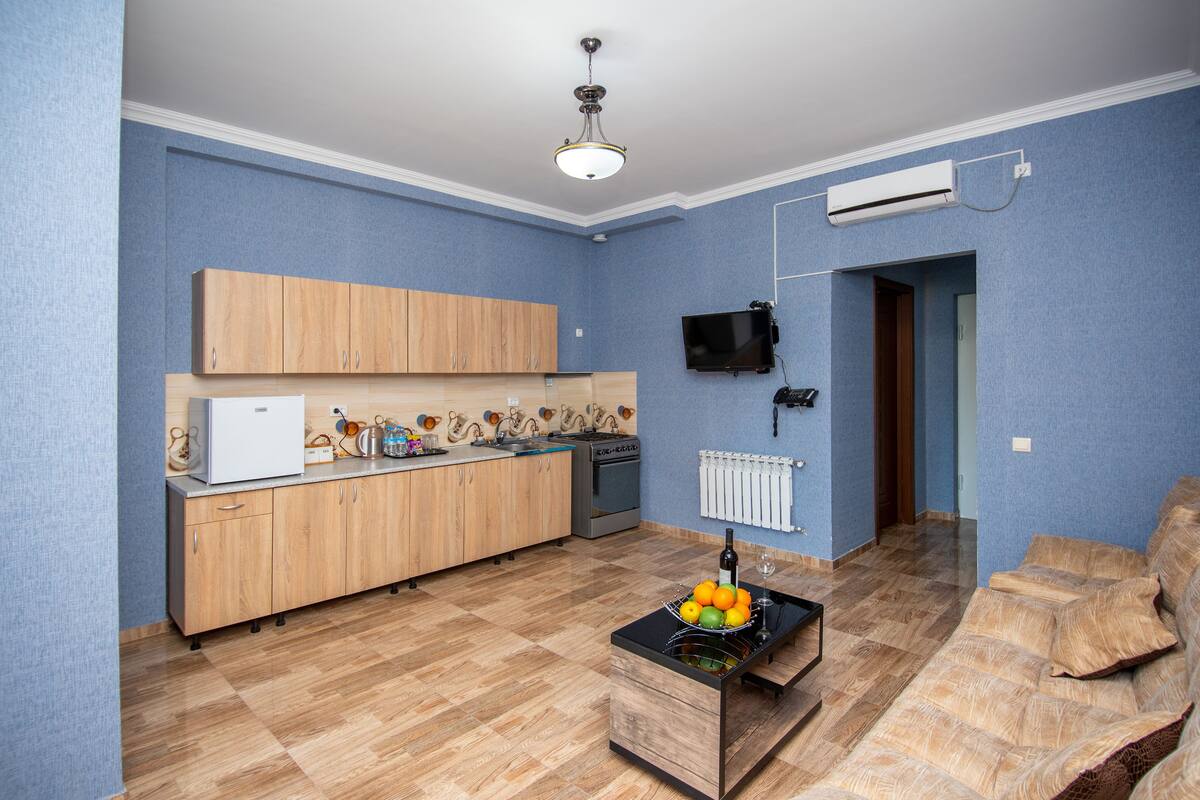 A compact living space with a kitchenette, a sofa, and a small dining area.