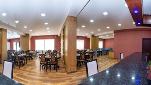 A spacious dining area with multiple tables and chairs, wooden pillars, and a modern ceiling design. - Penta Tbilisi (Tbilisi)