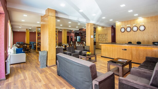 A hotel lobby with a reception desk, seating area, and a bar. - Penta Tbilisi (Tbilisi)