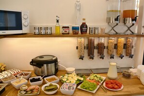 A buffet setup with various food items, condiments, and a food processor. - Vila Bohemia (Prague)