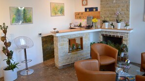A modern interior with a stone fireplace, a wooden reception desk, and leather chairs. - Vila Bohemia (Prague)