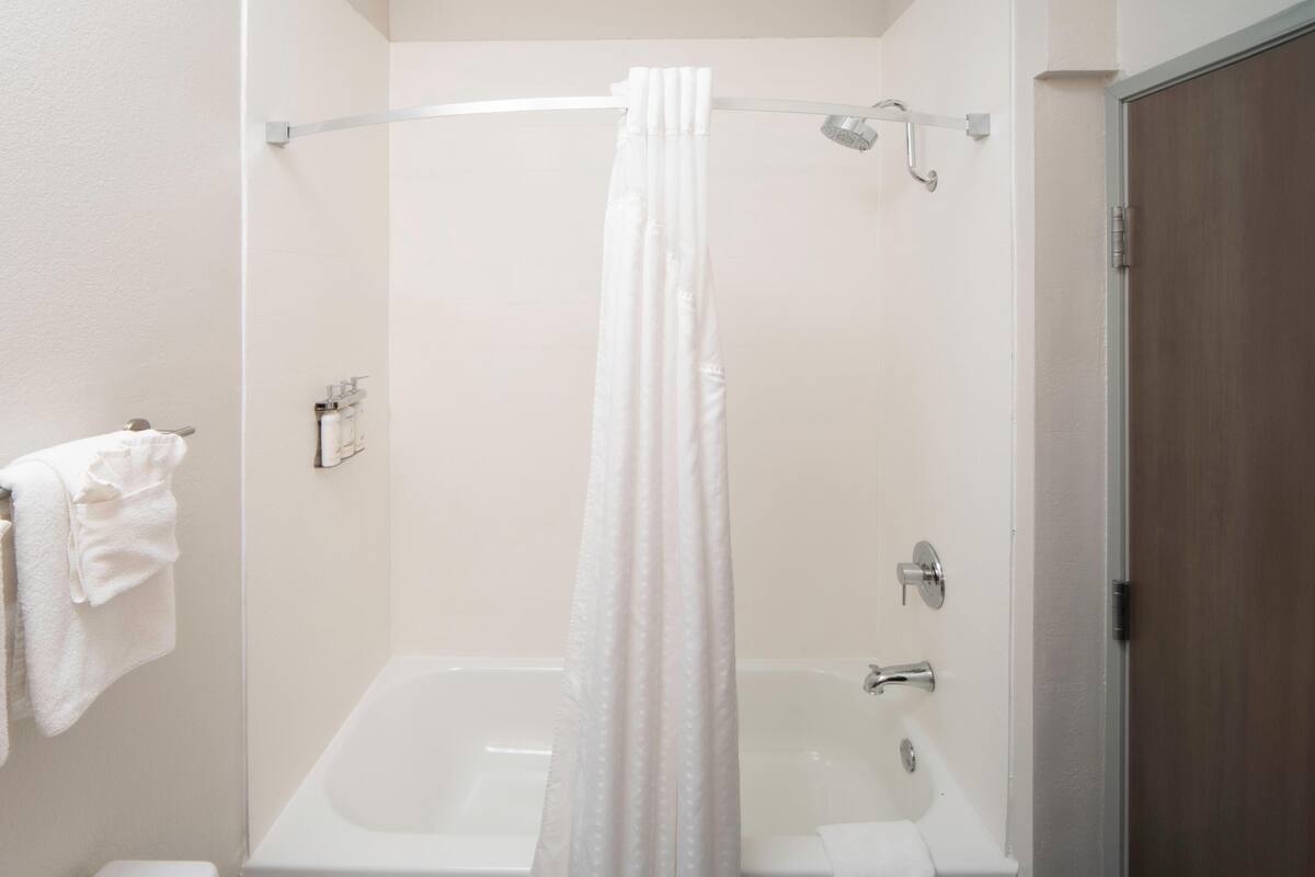 Un baño con bañera, cortina de ducha y un perchero para toallas.