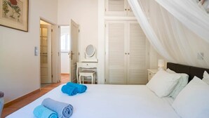 Ein Schlafzimmer mit einem Bett, einem Schreibtisch, einem Stuhl und einem Kleiderschrank.