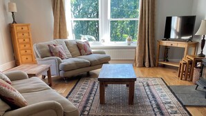 A living room with a sofa set, a coffee table, a TV, and a wooden floor. - Cottage for 6 in stunning rural location (Beech) (Crawfordjohn)
