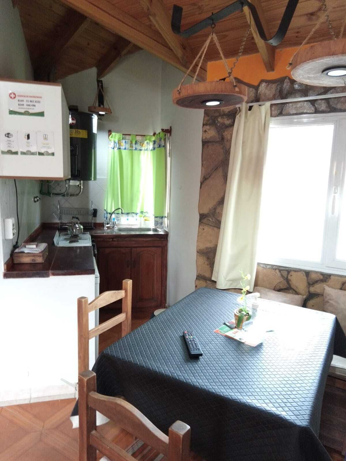 Een gezellige keuken met een houten tafel, stoelen en een hanglamp.