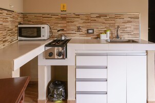 Una cocina moderna con microondas, estufa y lavamanos.