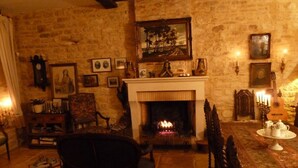 A cozy living room with a fireplace, stone walls, and traditional furnishings. - Maison les Beaux Arts (Mouzay)