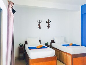 A hotel room with two single beds, white bedding, and a small potted plant on the nightstand. - G&Z Plan B Hostel (Siem Reap)