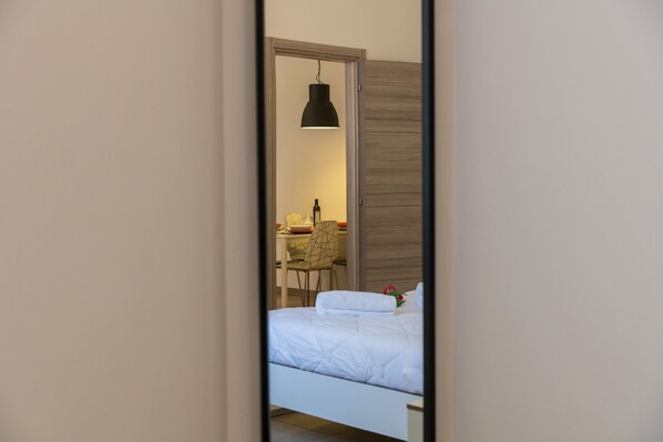 Un dormitorio con cama, escritorio y silla.
