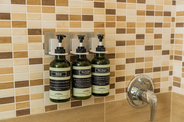 Three bottles of hair care products on a tiled wall. - Large Filippini residence a few meters from the Arena (Verona)