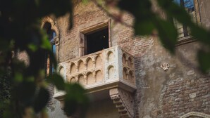 Ein historisches Gebäude mit Balkon und Bogenfenstern.