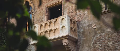 Un edificio histórico con un balcón y ventanas de arco.