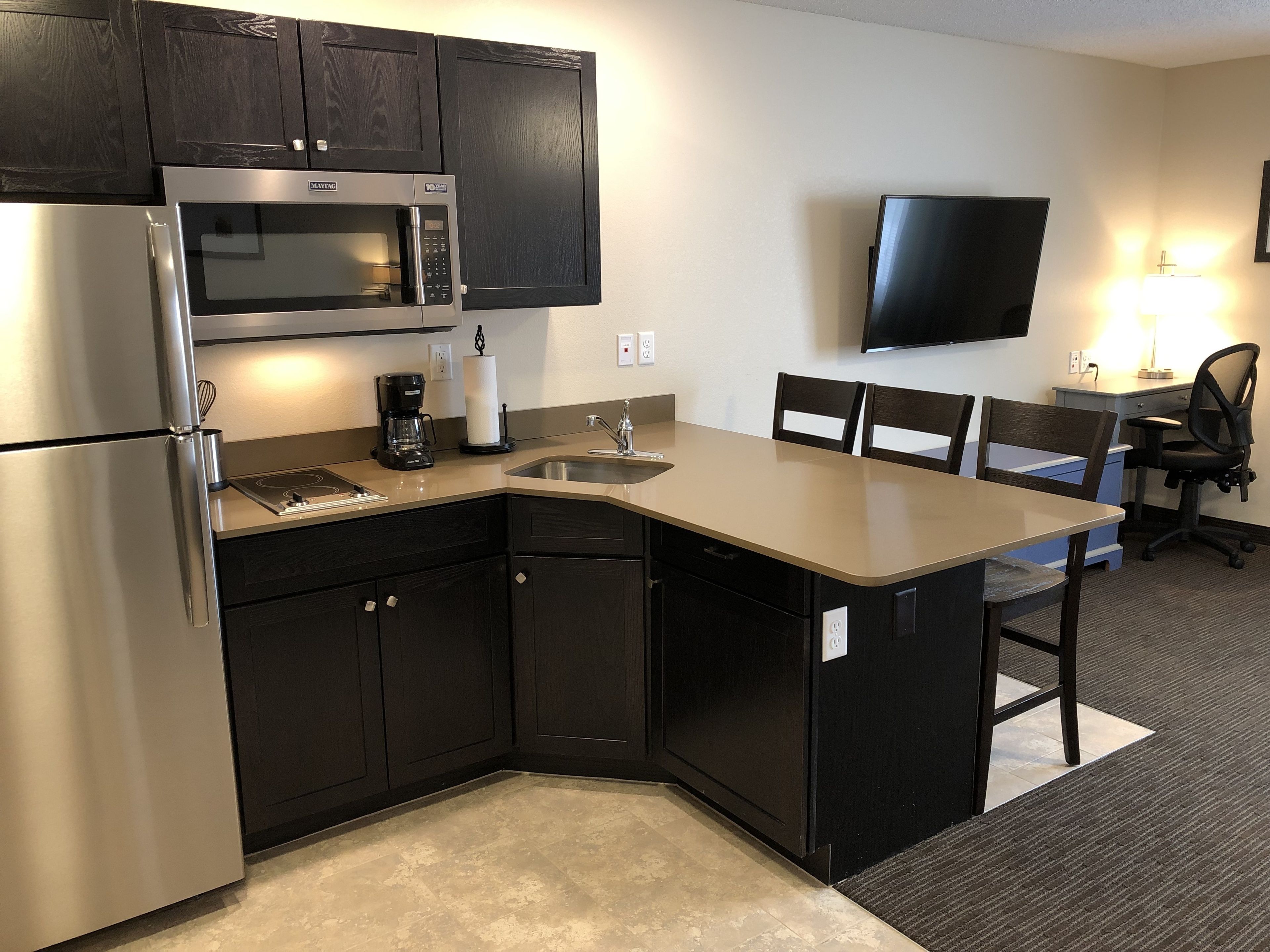 standard 2 queen room | living area | 50-inch flat-screen tv with premium tv channels, tv, books