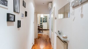 A hallway with framed pictures on the walls, a radiator, and a mirror on the right. - Τhe welcoming Rocchetto residence at 25m from P. Erbe (Verona)