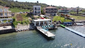 A waterfront property with a dock, outdoor seating, and a pool area. - Cunda Mira Butik Otel (Ayvalik)