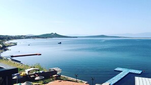 Ein Küstenblick mit einer Anlegestelle, einem Lounge-Bereich und ruhiger See.