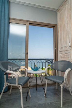 Ein Balkon mit zwei Stühlen, einem Tisch und Blick aufs Meer.