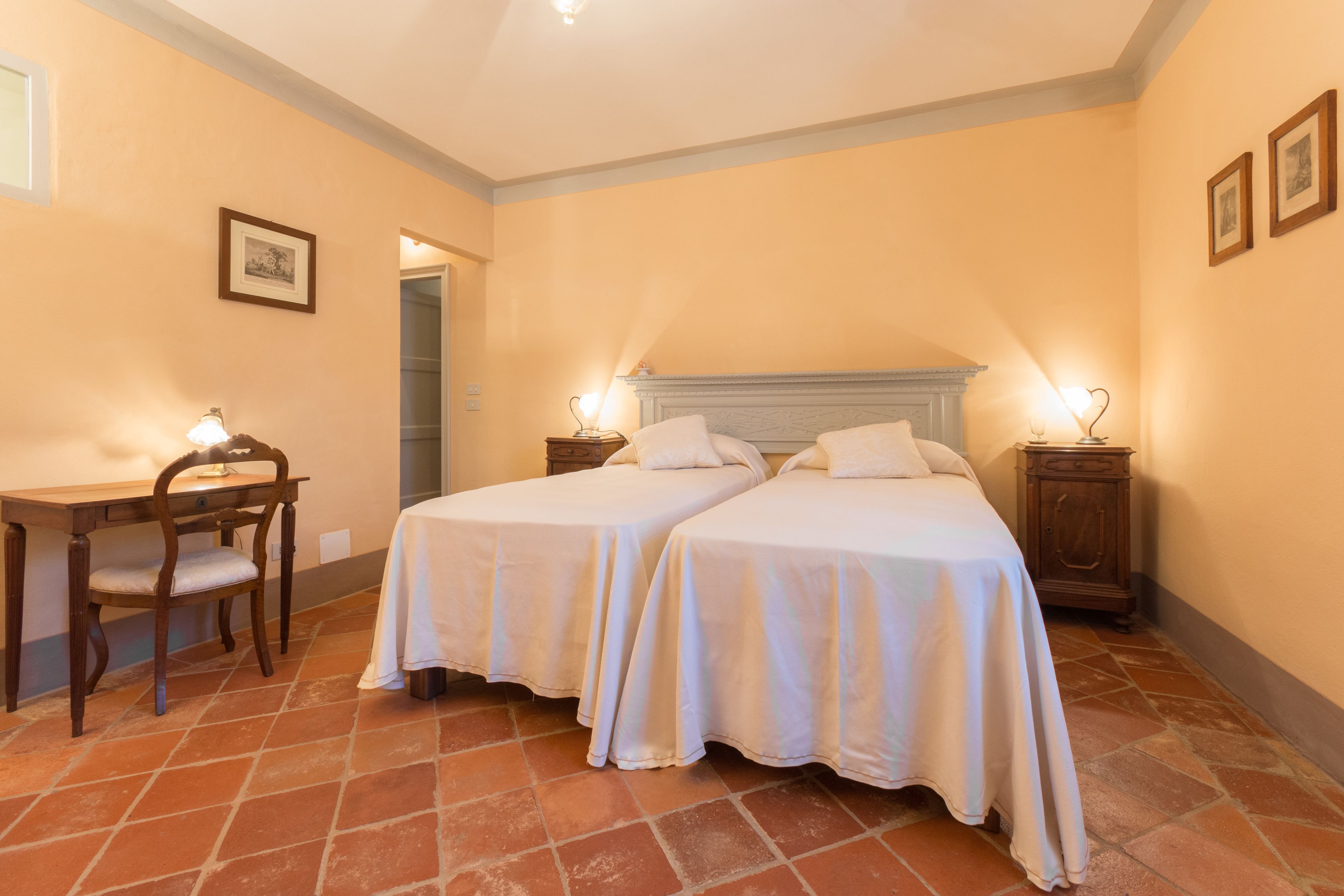 A room with two beds, a desk, and a chair.