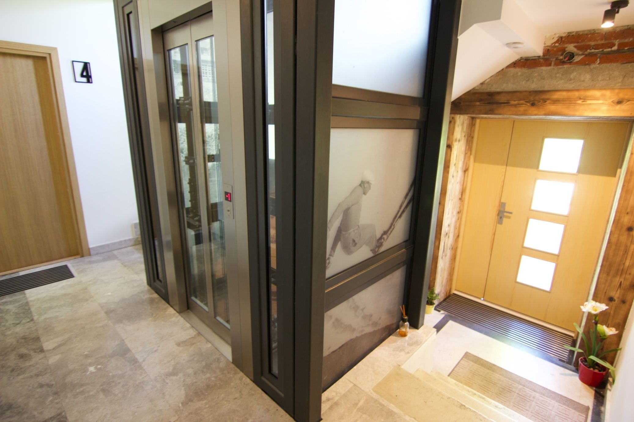 A hallway with a wooden door, a glass door, and a tiled floor.