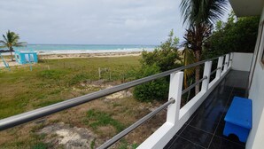 Un balcon avec vue sur la plage et l’océan.