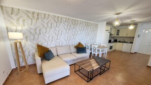 Un saló modern amb sofà, taula de centre i zona de menjador.