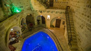 A stone building with a central pool, multiple arches, and a staircase. - Royal Cave Hotel (Ürgüp)