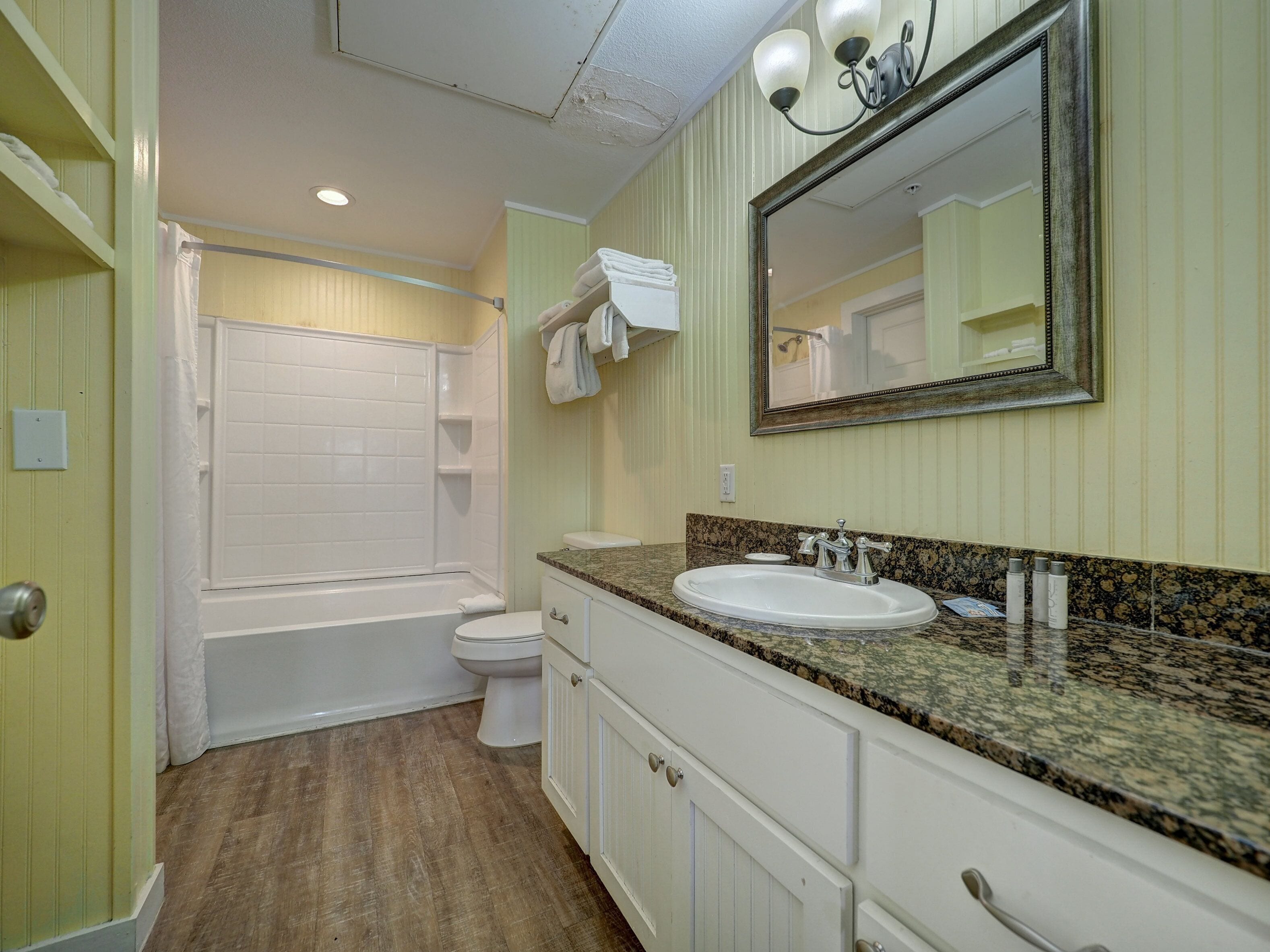 A bathroom with a bathtub, toilet, sink, and vanity.