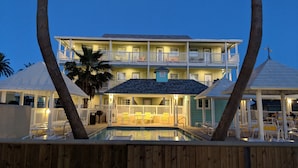 A multi-story hotel with a pool, outdoor seating, and a beach view. - Seashell Village Resort near the beach with kitchens (Port Aransas)