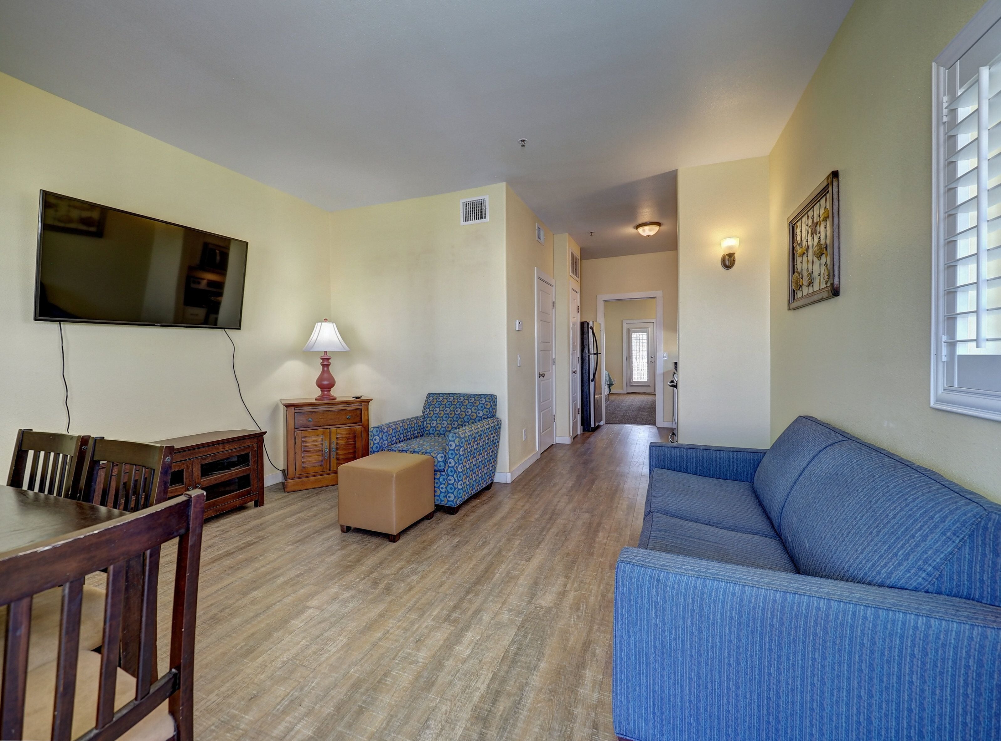 A living room with a TV, sofa, and a dining table.