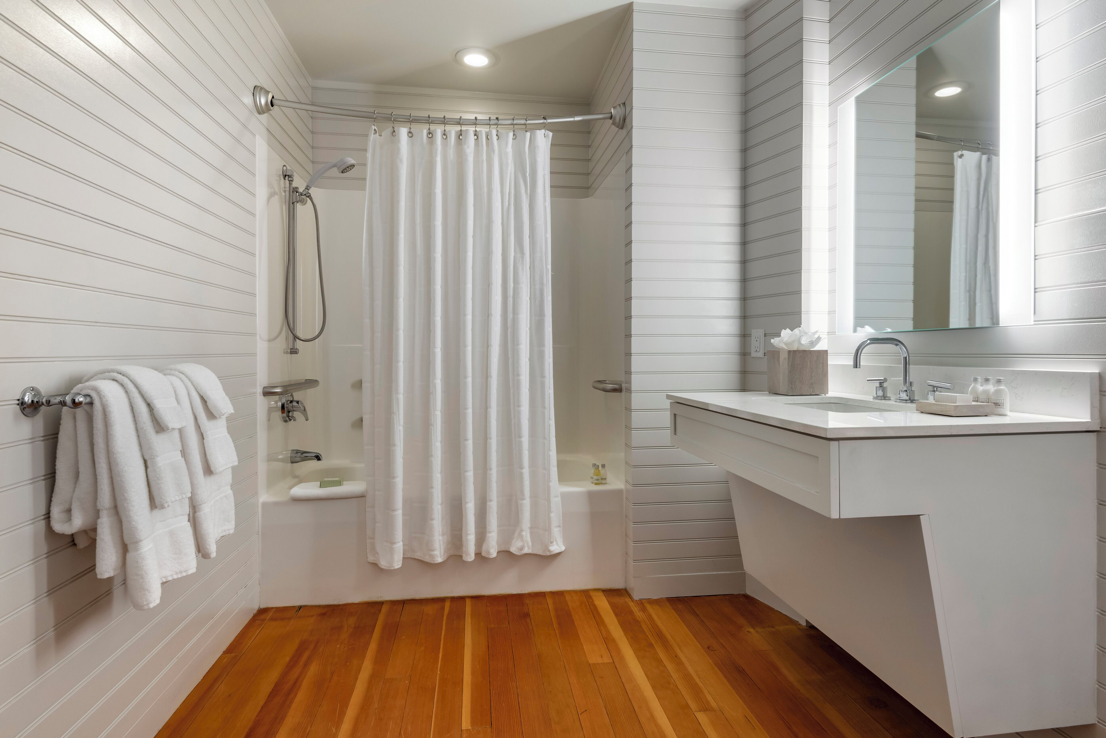 Ein modernes Badezimmer mit Dusche, Badewanne und Waschtisch mit Spiegel.