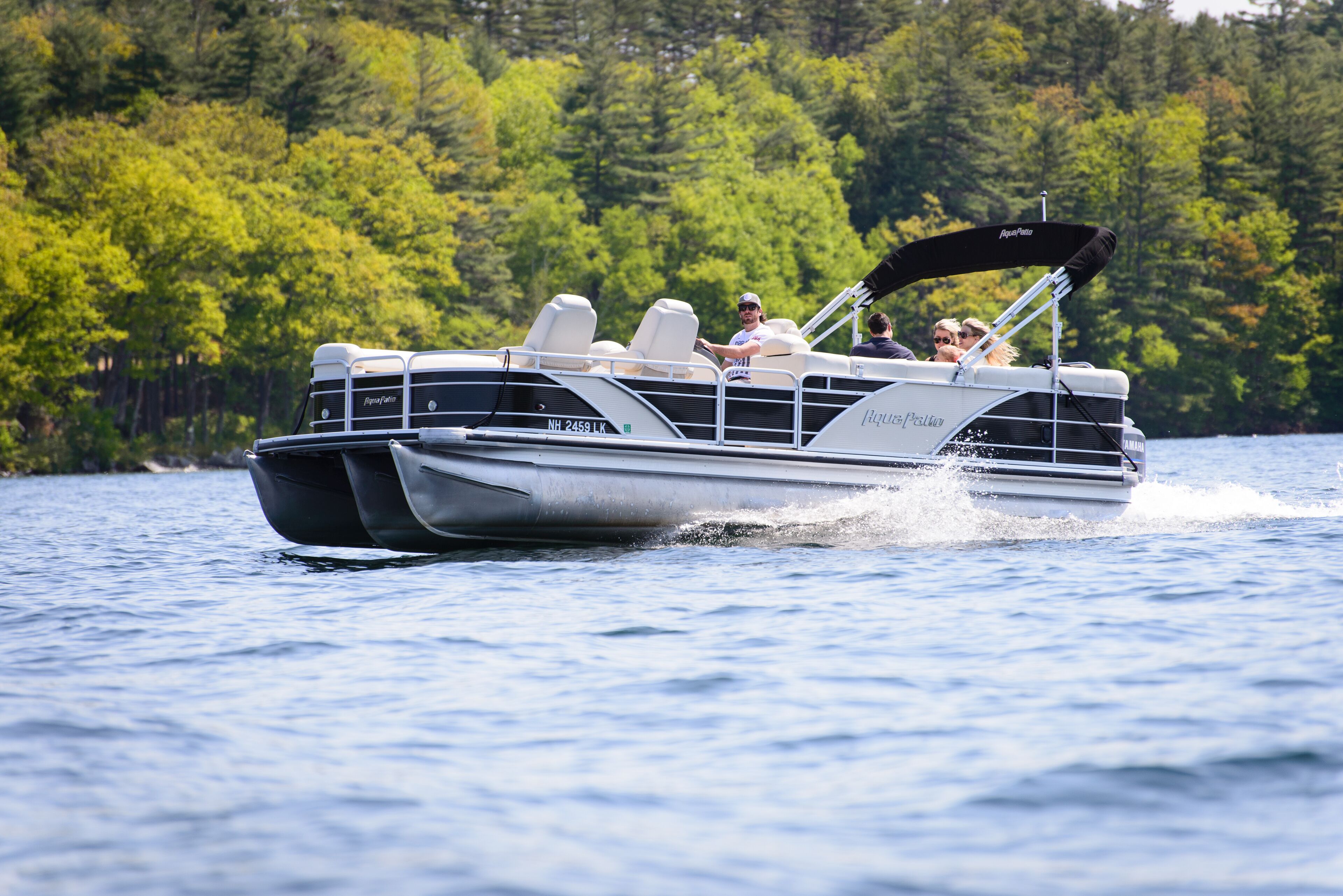 Un barco a motor con diseño en blanco y negro, equipado con una cabana y transportando pasajeros.