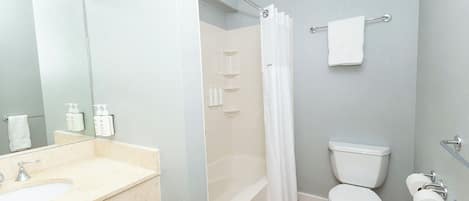 A modern bathroom with a sink, mirror, toilet, and shower.