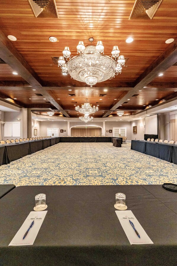 Une grande salle de conférence avec une longue table, de nombreuses chaises et un lustre.
