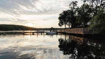 A calm lake with a wooden dock and a gazebo.