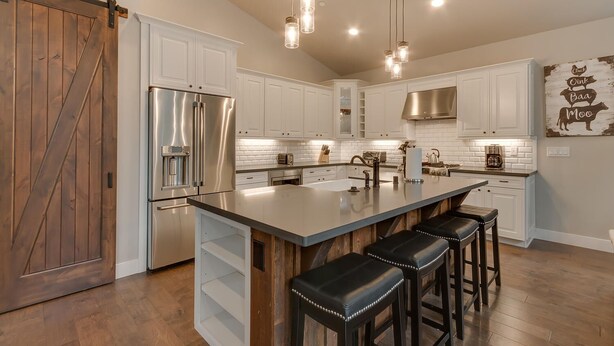 A modern kitchen with white cabinets, a stainless steel refrigerator, a large island with bar stools, and pendant lighting. - Golden Tee, Classic Arcade, Slot Machine, Spa, 7mins to Beach/ Lake, Newly Built – Sierra Escape (South Lake Tahoe)