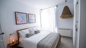 Ein Schlafzimmer mit Bett, Nachttisch und einer Pendelleuchte.